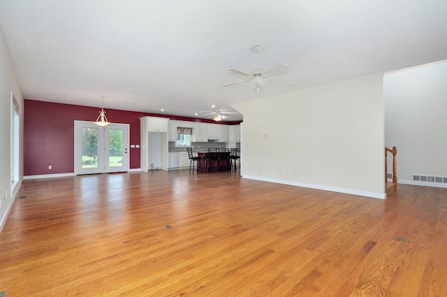 unfurnished living room featuring ceiling fan and light hardwood / wood-style flooring