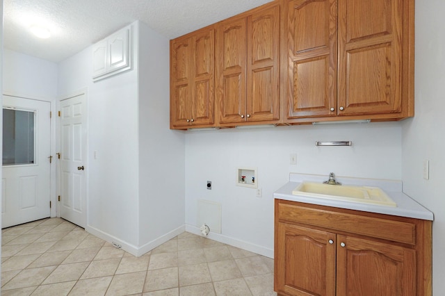 laundry area featuring cabinets, hookup for a washing machine, sink, electric dryer hookup, and a textured ceiling