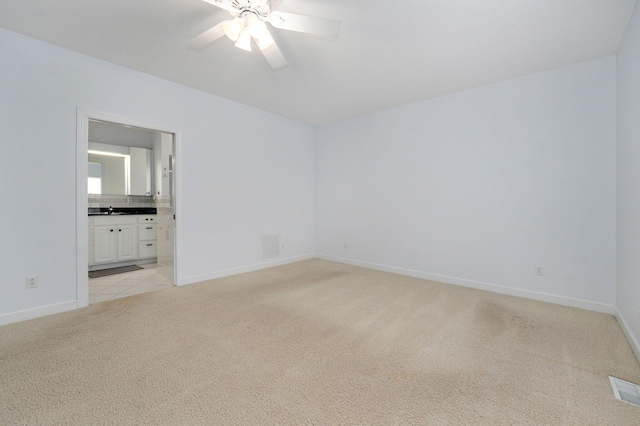 carpeted empty room with ceiling fan and sink