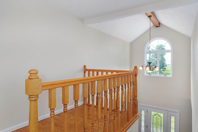 stairway featuring wood-type flooring and lofted ceiling with beams