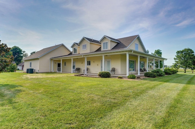 country-style home with central air condition unit, a front yard, and covered porch