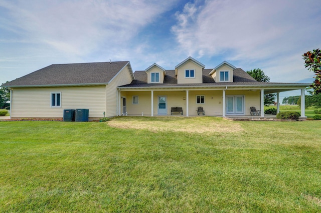 rear view of property with cooling unit, a porch, and a yard