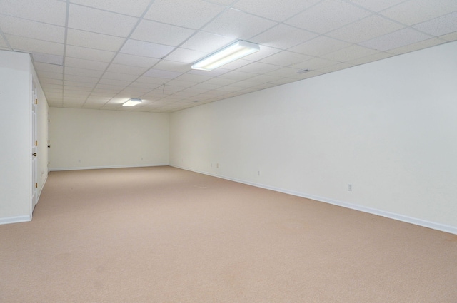 spare room featuring a drop ceiling and light carpet