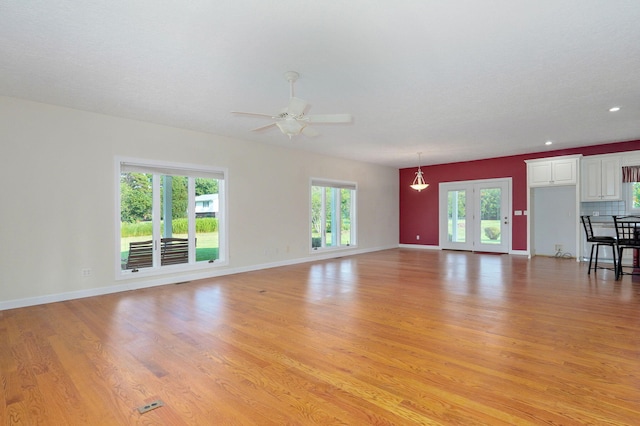 unfurnished living room with ceiling fan, a textured ceiling, and light hardwood / wood-style flooring