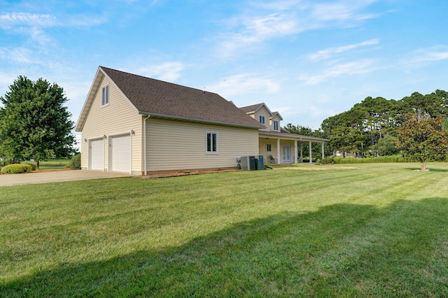 view of side of home with central AC unit, a lawn, and a garage