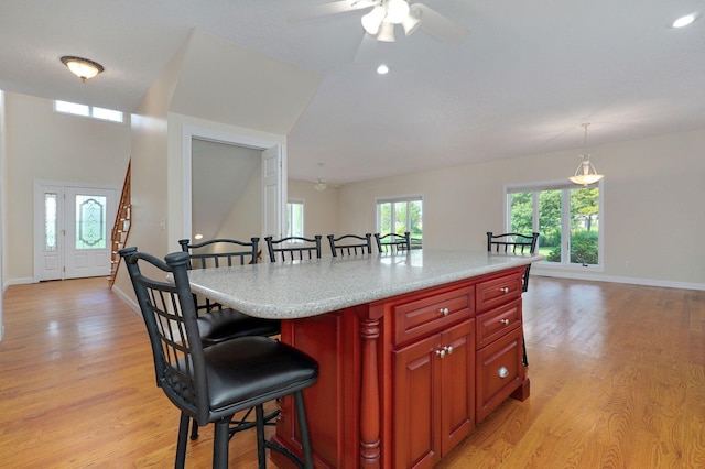 kitchen featuring pendant lighting, a kitchen island, light hardwood / wood-style flooring, and ceiling fan