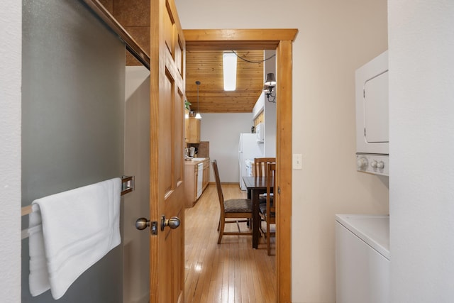 interior space with wooden ceiling, stacked washer / dryer, and light wood-type flooring