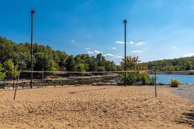 view of home's community with a water view and volleyball court