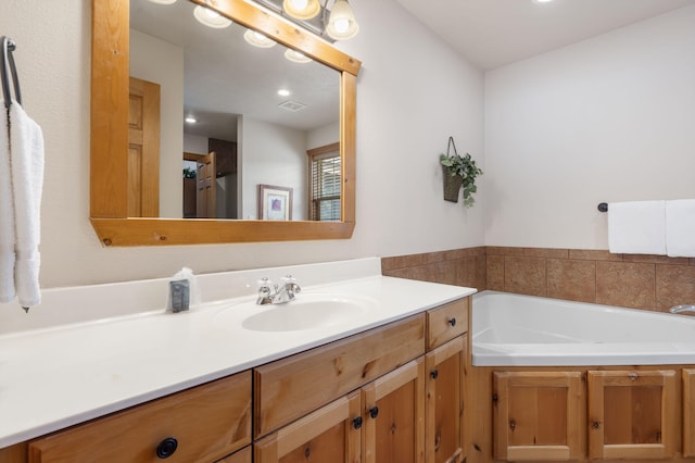 bathroom with a tub to relax in and vanity