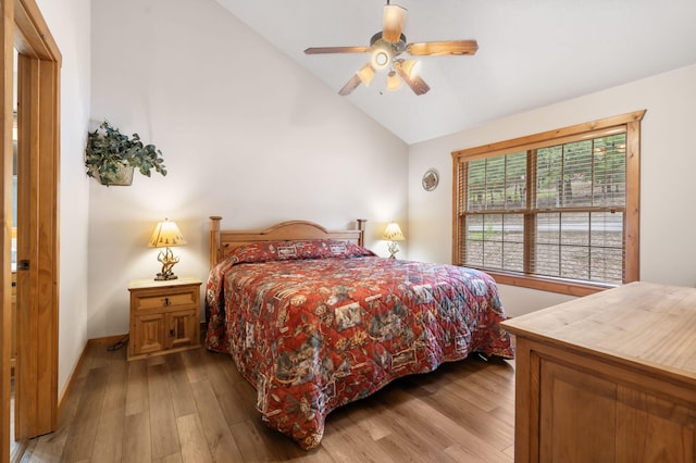 bedroom with ceiling fan, lofted ceiling, and light hardwood / wood-style floors