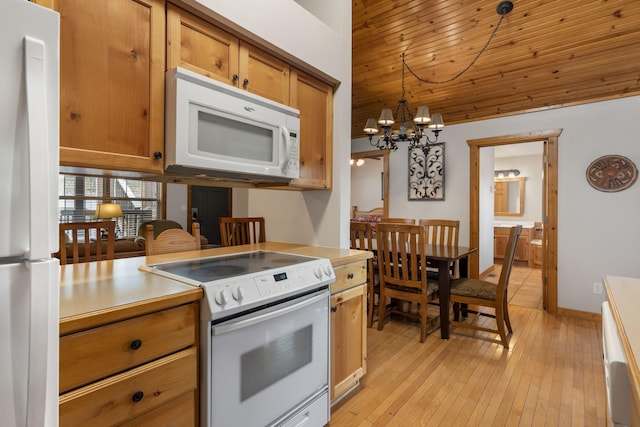 kitchen with decorative light fixtures, a chandelier, light hardwood / wood-style floors, and white appliances