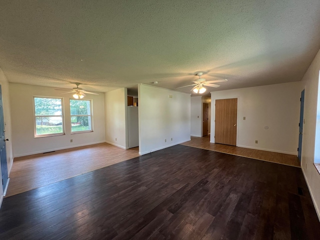 empty room featuring ceiling fan, dark hardwood / wood-style floors, and a textured ceiling