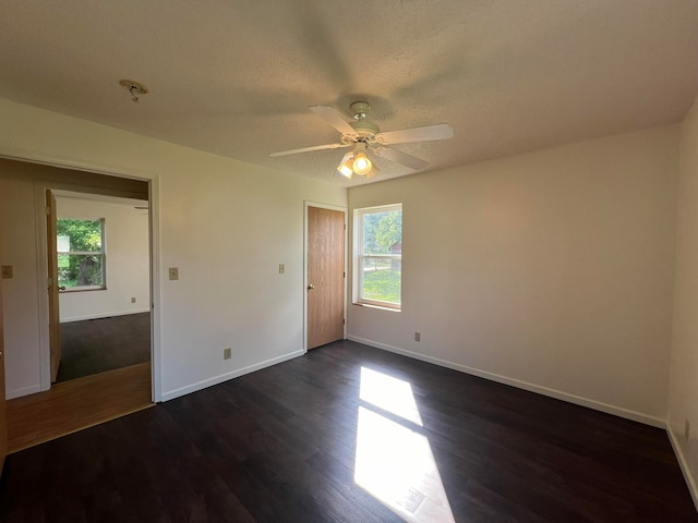 spare room featuring a textured ceiling, ceiling fan, and dark hardwood / wood-style flooring