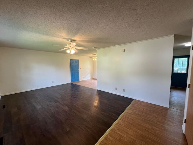 unfurnished room with ceiling fan, dark wood-type flooring, and a textured ceiling