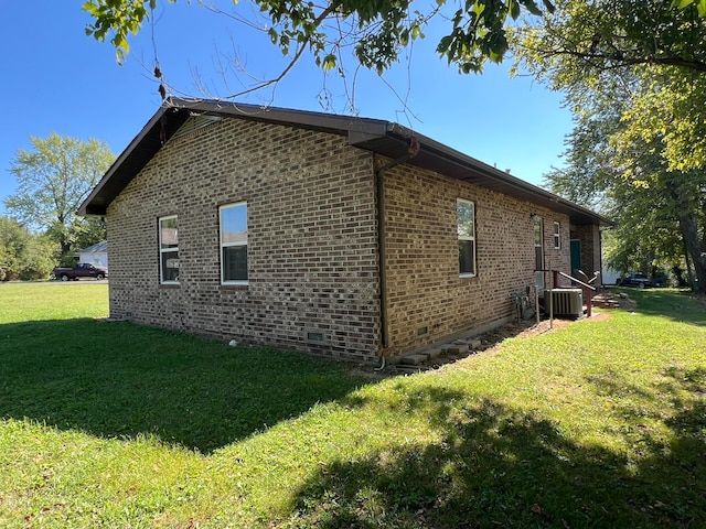 view of home's exterior with cooling unit and a lawn