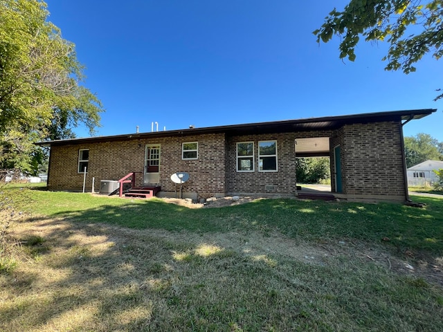 back of property with a yard and central air condition unit