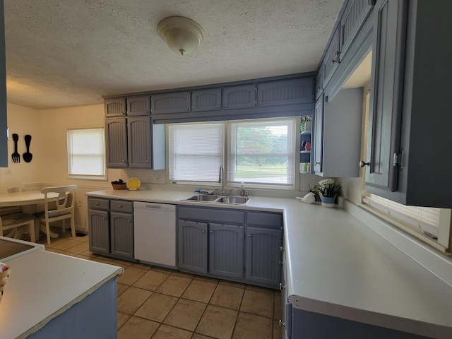 kitchen featuring light tile patterned flooring, a textured ceiling, sink, and dishwasher