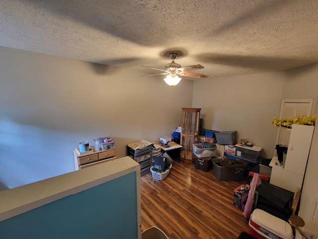 interior space with ceiling fan, a textured ceiling, and dark hardwood / wood-style floors