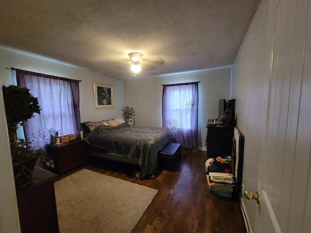 bedroom with dark hardwood / wood-style flooring, a textured ceiling, and ceiling fan