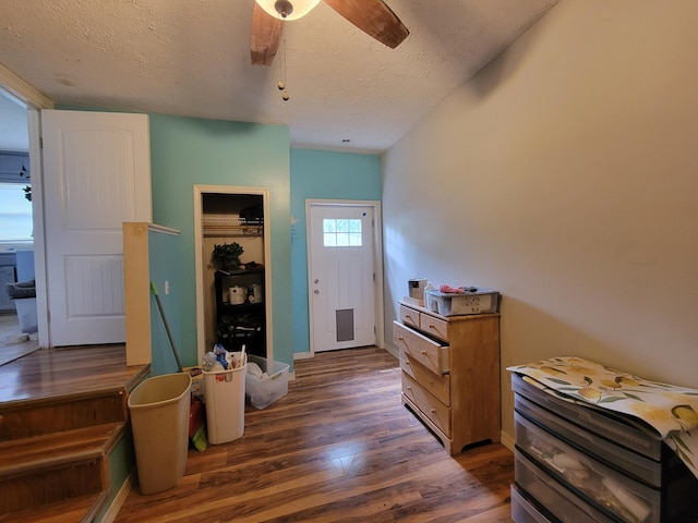 foyer with dark hardwood / wood-style floors, a textured ceiling, and ceiling fan