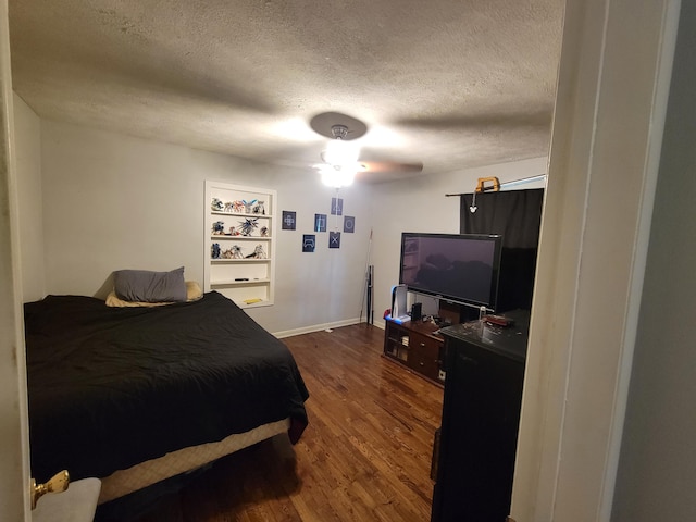 bedroom with dark wood-type flooring, ceiling fan, and a textured ceiling