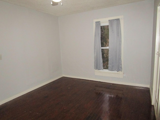 spare room featuring wood-type flooring and a textured ceiling