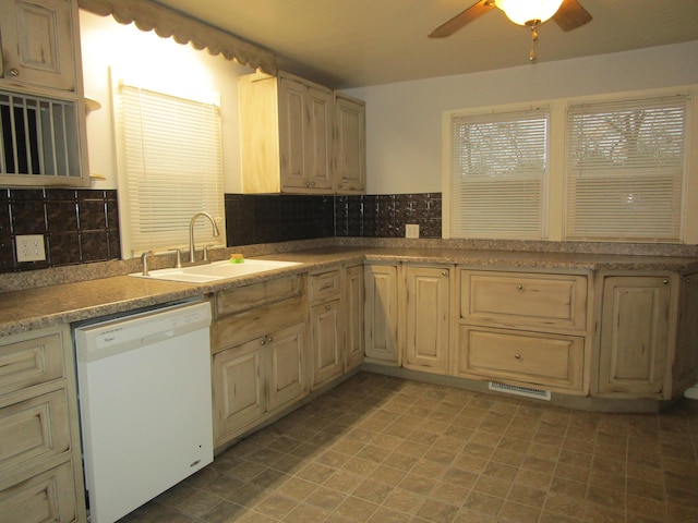 kitchen with decorative backsplash, light brown cabinetry, white dishwasher, ceiling fan, and sink