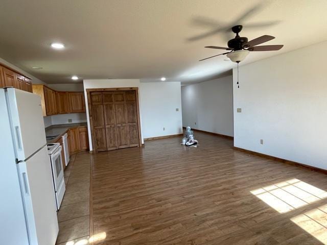 kitchen featuring ceiling fan, white appliances, and wood-type flooring