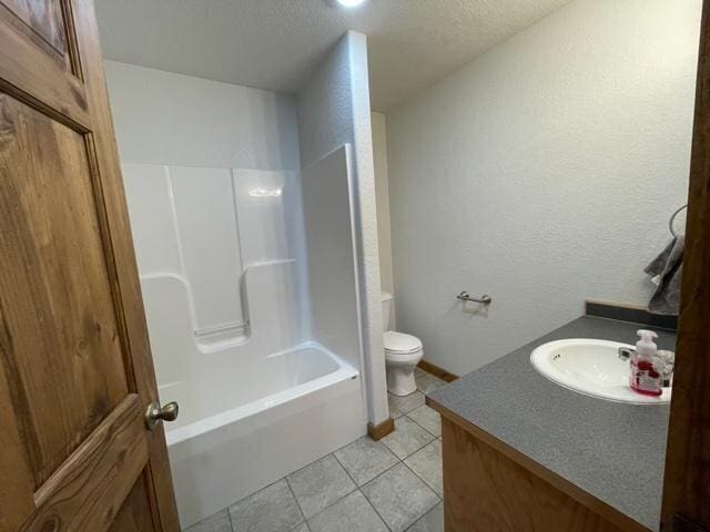 full bathroom featuring tile patterned floors, vanity, toilet, and  shower combination