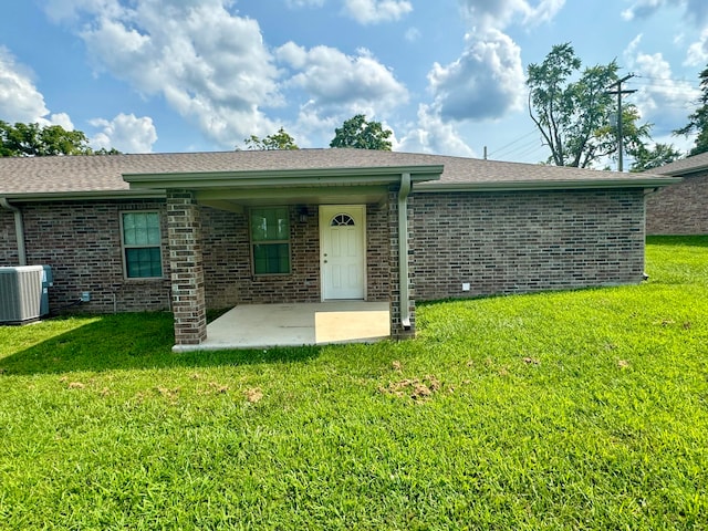 rear view of house with a yard and central AC