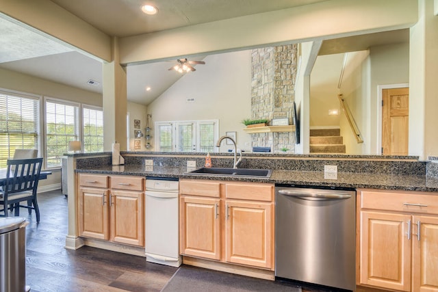 kitchen featuring ceiling fan, stainless steel dishwasher, sink, dark hardwood / wood-style flooring, and dark stone counters