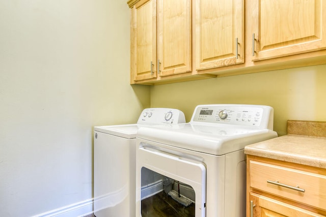 laundry room with washing machine and clothes dryer and cabinets