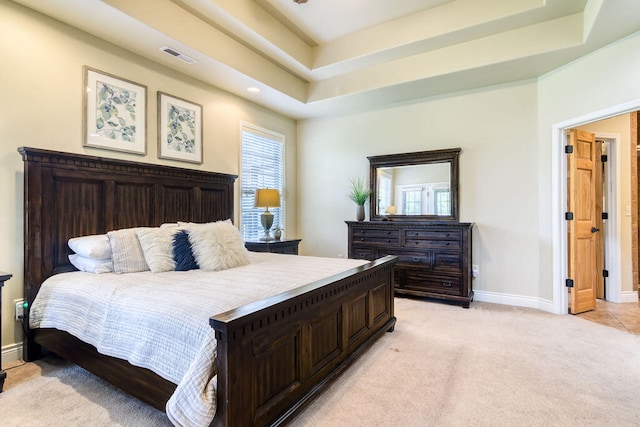 carpeted bedroom featuring a tray ceiling