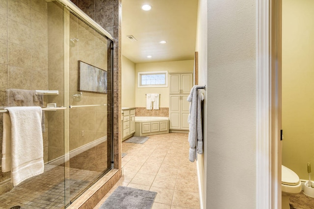 bathroom featuring tile patterned flooring, a shower with shower door, vanity, and toilet