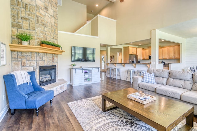 living room featuring a fireplace, high vaulted ceiling, and dark wood-type flooring