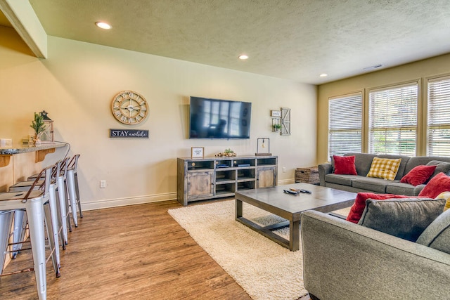 living room with wood-type flooring and a textured ceiling