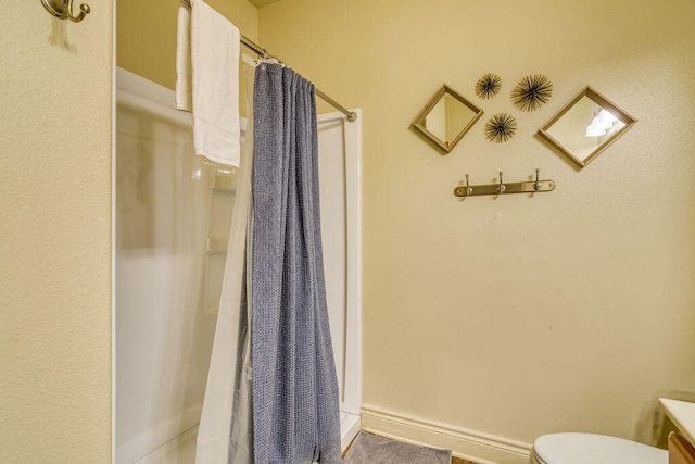 bathroom with a shower with shower curtain, vanity, and toilet