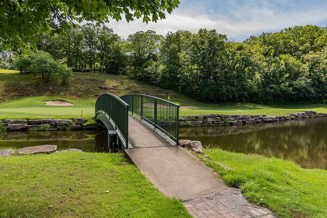 view of dock featuring a water view and a lawn