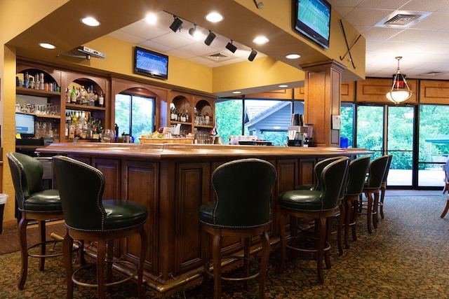 bar with decorative light fixtures and dark colored carpet