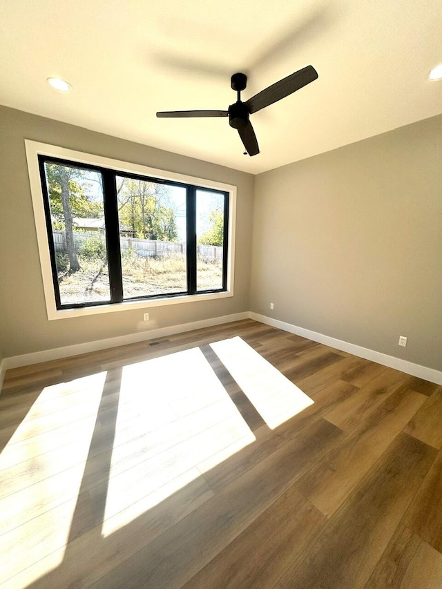 empty room with ceiling fan and dark hardwood / wood-style flooring