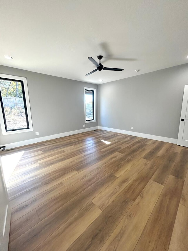 empty room with ceiling fan and wood-type flooring