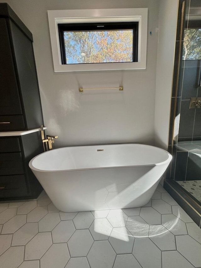 bathroom featuring tile patterned floors and a bath