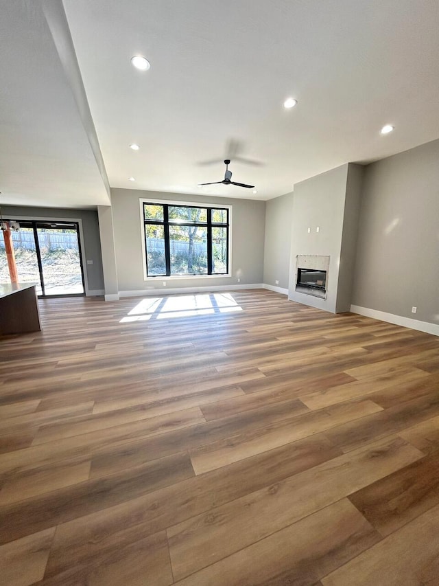 unfurnished living room with hardwood / wood-style flooring and ceiling fan