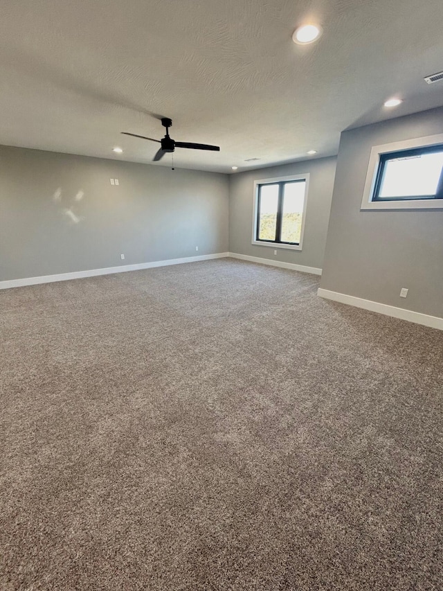 carpeted spare room with ceiling fan and a textured ceiling