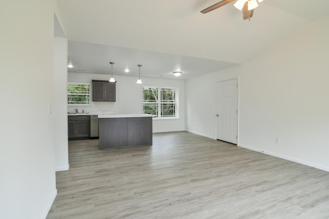 kitchen with ceiling fan, hanging light fixtures, sink, dark brown cabinets, and light wood-type flooring