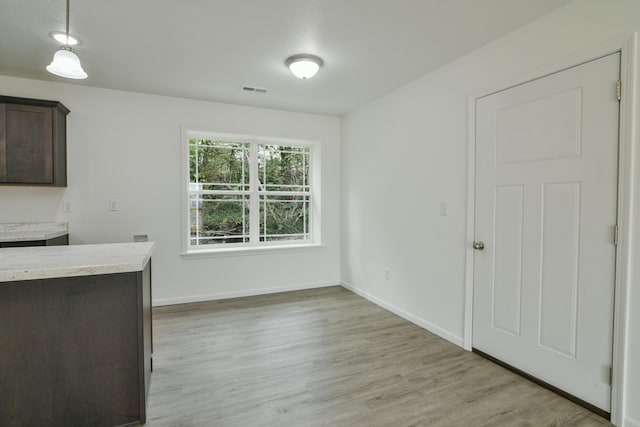 unfurnished dining area featuring light wood-type flooring