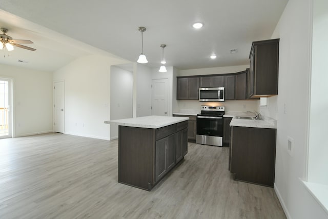 kitchen featuring a kitchen island, light hardwood / wood-style flooring, dark brown cabinetry, stainless steel appliances, and hanging light fixtures