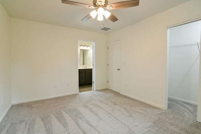 unfurnished bedroom with light carpet, a closet, a spacious closet, and ceiling fan