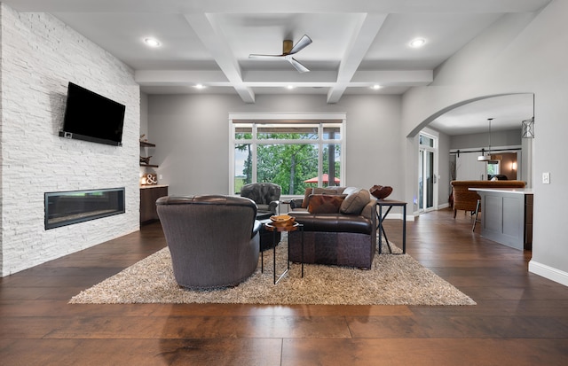 living room with a fireplace, dark hardwood / wood-style floors, beam ceiling, and coffered ceiling