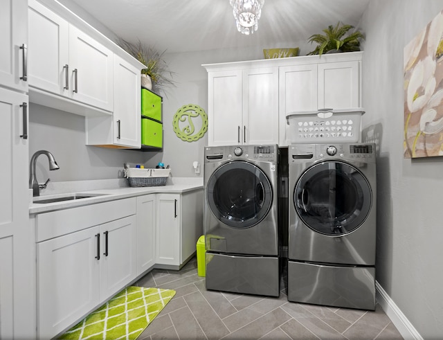 laundry room featuring light tile patterned flooring, washing machine and clothes dryer, sink, and cabinets